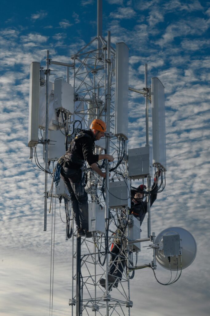 pexels-photo-19661549-19661549 Two technicians working on a cell tower against a cloudy sky, Belgrade.